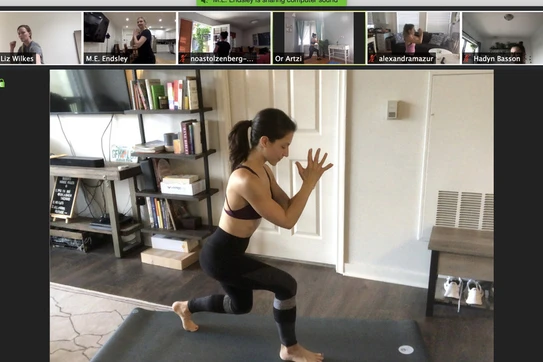Woman demonstrating pilates moves onscreen 