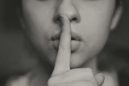 Grayscale photo of woman doing silent hand sign photo. Photo by Kristina Flour on Unsplash.