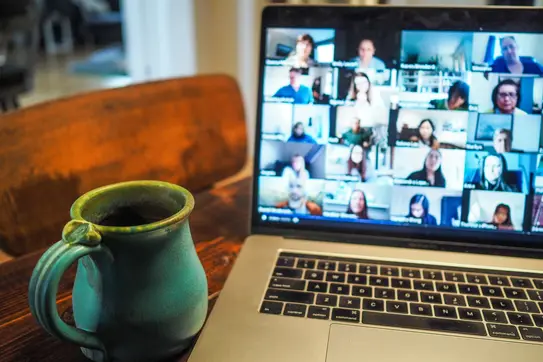 an open laptop computer shows a remote meeting in progress