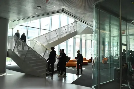 Students walking up the stairs inside Kravis Hall